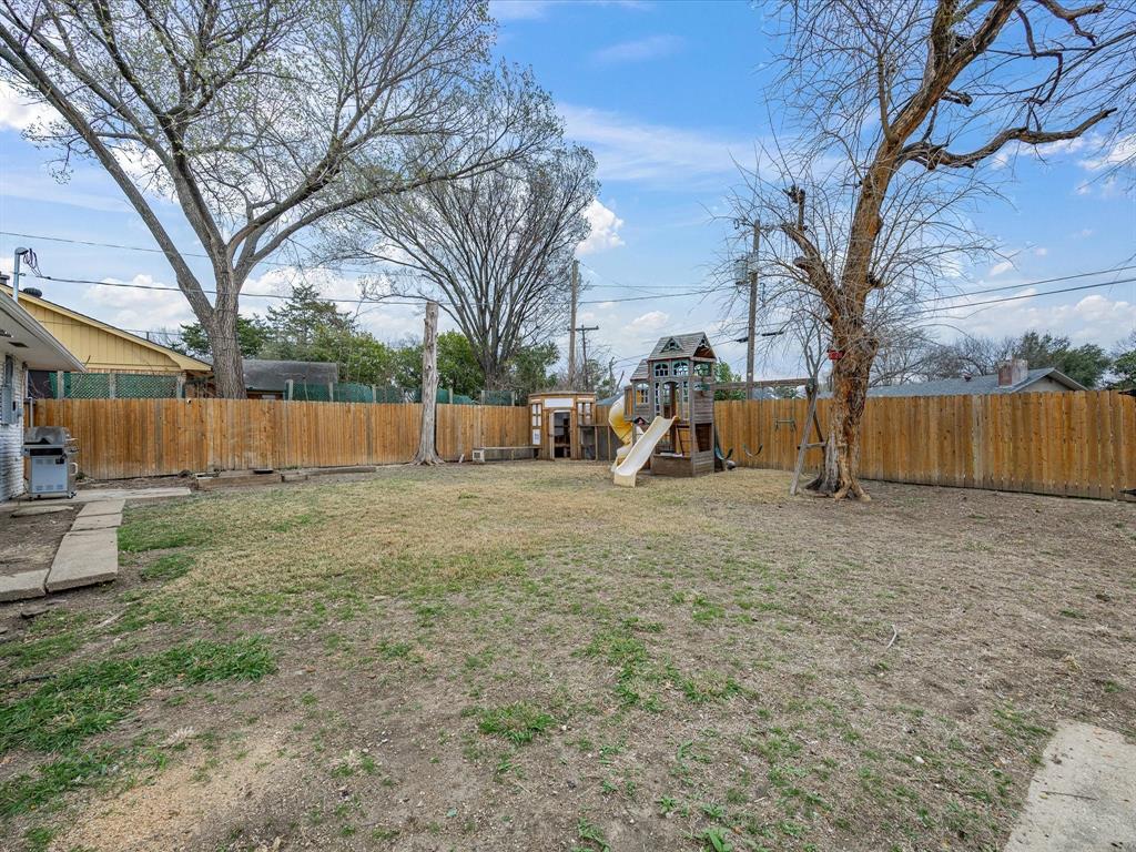 514 West Ridgewood Drive Garland, TX 75041 - Photo 29 of 39 a view of backyard with wooden fence and a tree