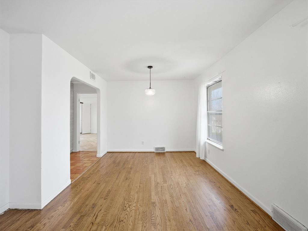 514 West Ridgewood Drive Garland, TX 75041 - Photo 6 of 39 an empty room with wooden floor and windows