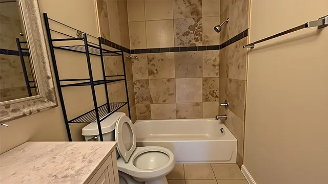 a bathroom with a granite countertop bathtub a toilet and a shower
