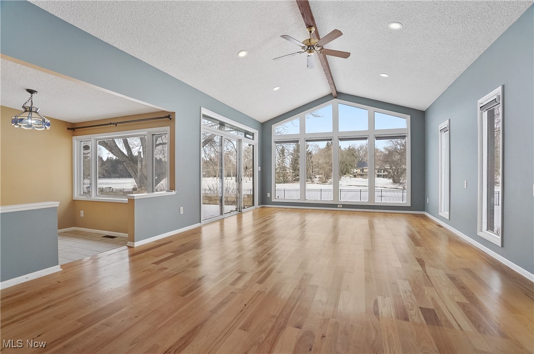 1094 San Raphael Drive Akron, OH 44333 - Photo 15 of 50 Unfurnished living room featuring light wood finished floors, a ceiling fan, a chandelier, and a textured ceiling
