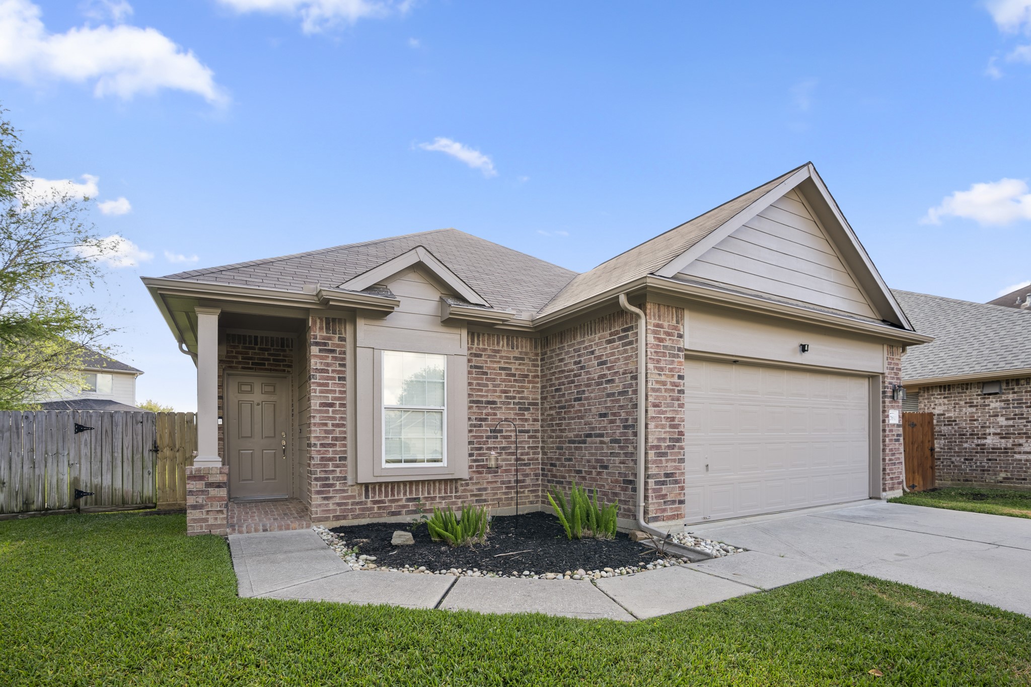 21810 Mansfield Bluff Lane Spring, TX 77379 - Photo 2 of 34 A closer look highlights the 2-car garage with garage door opener and the sidewalk leading up to the covered front porch, guiding you toward the entry.