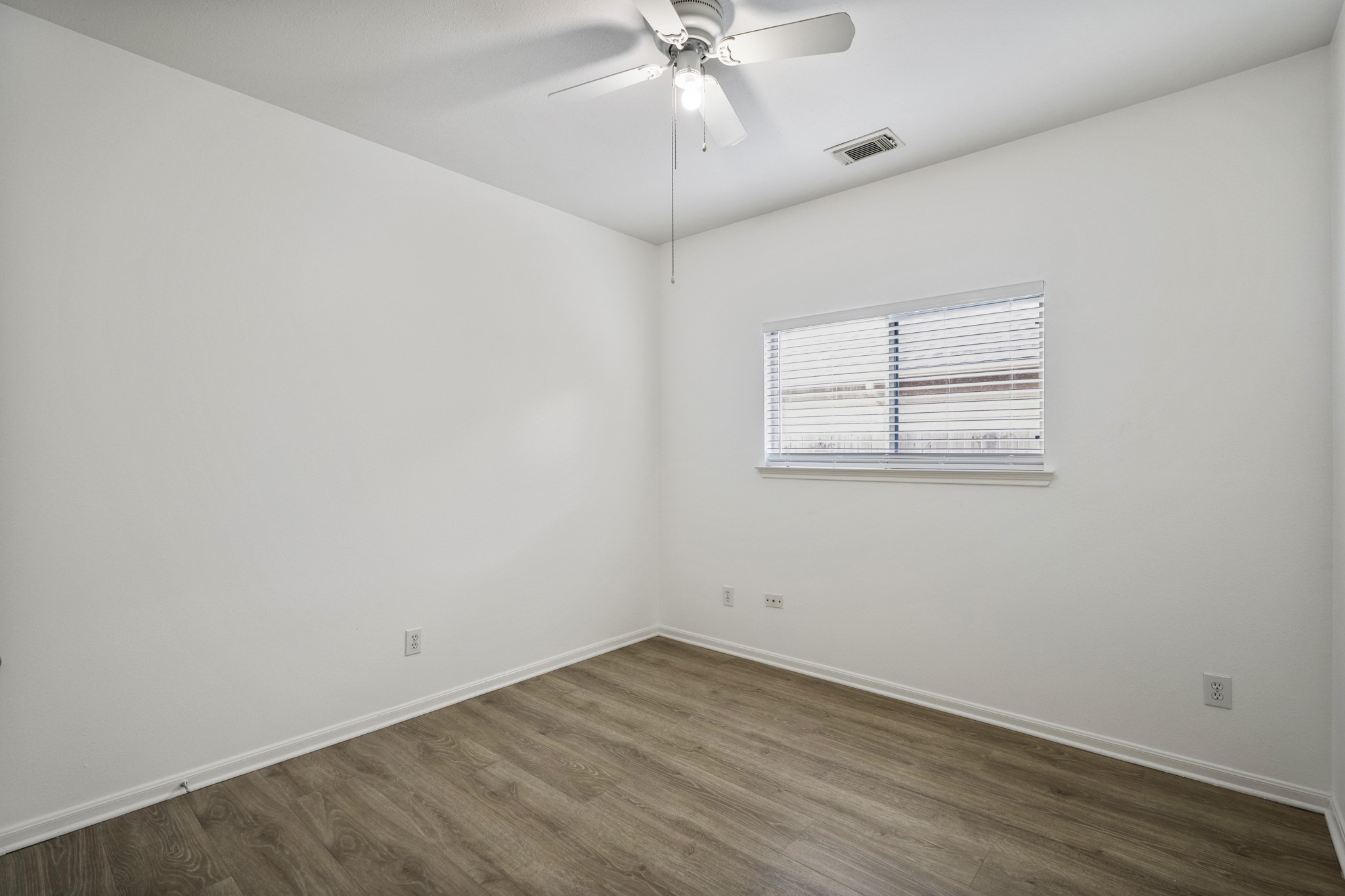 21810 Mansfield Bluff Lane Spring, TX 77379 - Photo 26 of 34 The third bedroom is positioned down the hallway, with a window bringing in natural light and a closet along the wall, continuing the same flooring throughout.