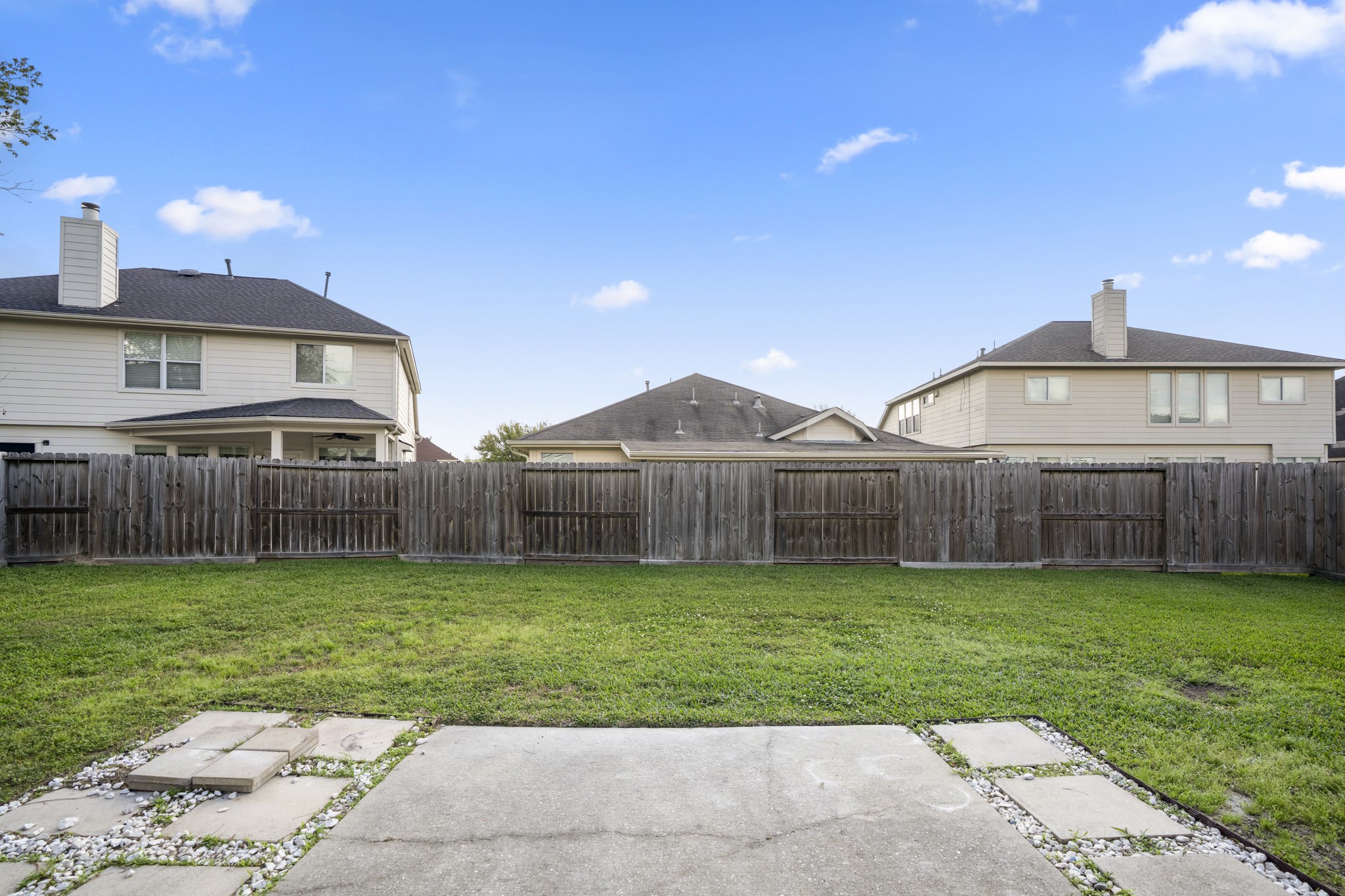 21810 Mansfield Bluff Lane Spring, TX 77379 - Photo 29 of 34 Out back, the yard extends beyond the patio, offering open green space with room to spread out or enjoy time outside.
