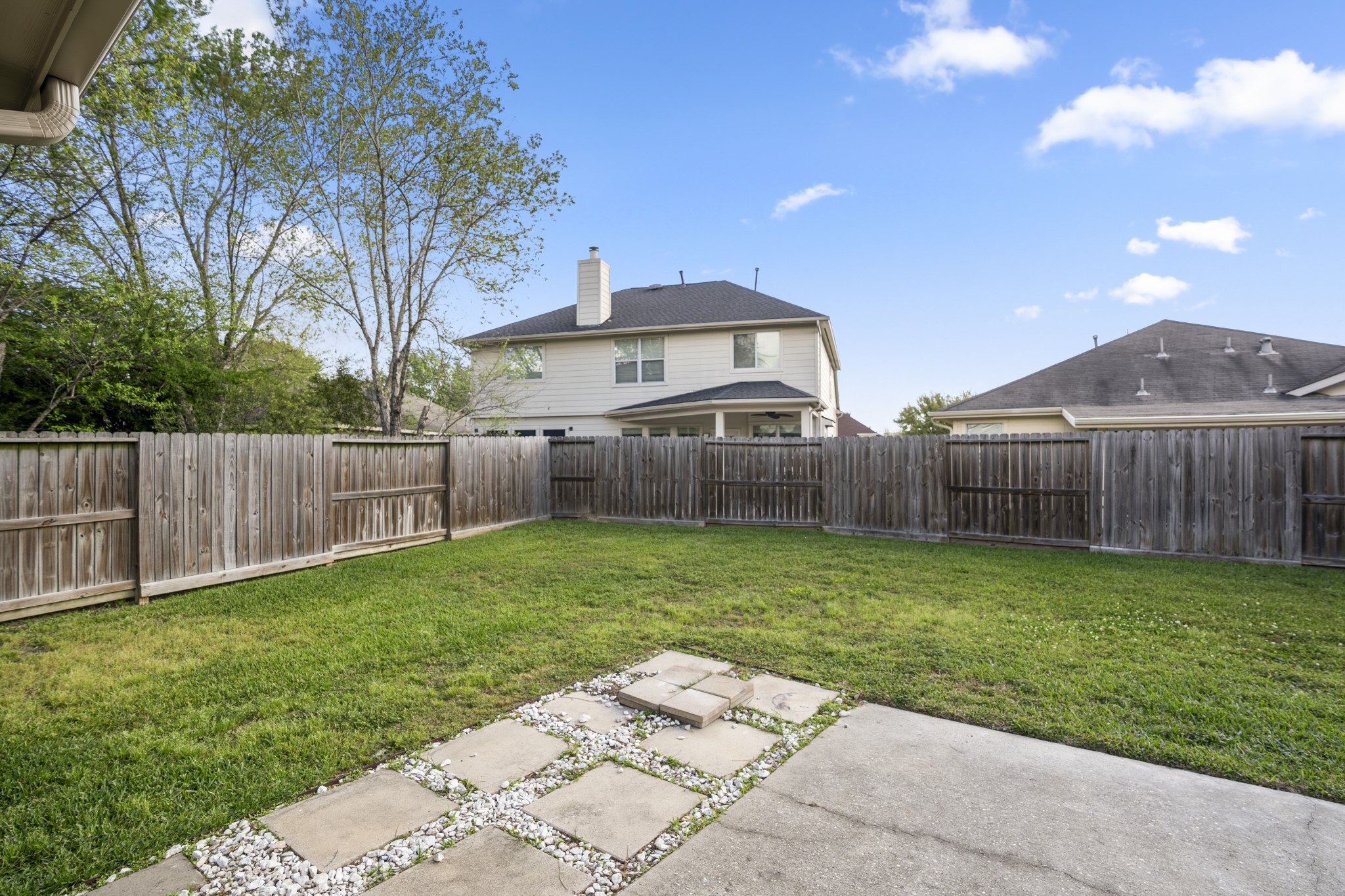 21810 Mansfield Bluff Lane Spring, TX 77379 - Photo 30 of 34 Another view of the backyard shows the full depth of the space, with a fenced perimeter and a patio that sits just off the home, creating a natural extension of the indoor living area.
