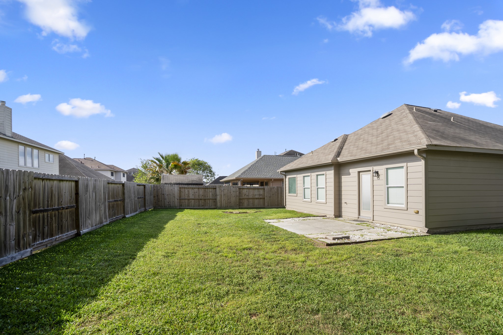 21810 Mansfield Bluff Lane Spring, TX 77379 - Photo 31 of 34 A full view of the backyard shows open space of the yard, offering a spot to step outside, unwind, or enjoy time outdoors.