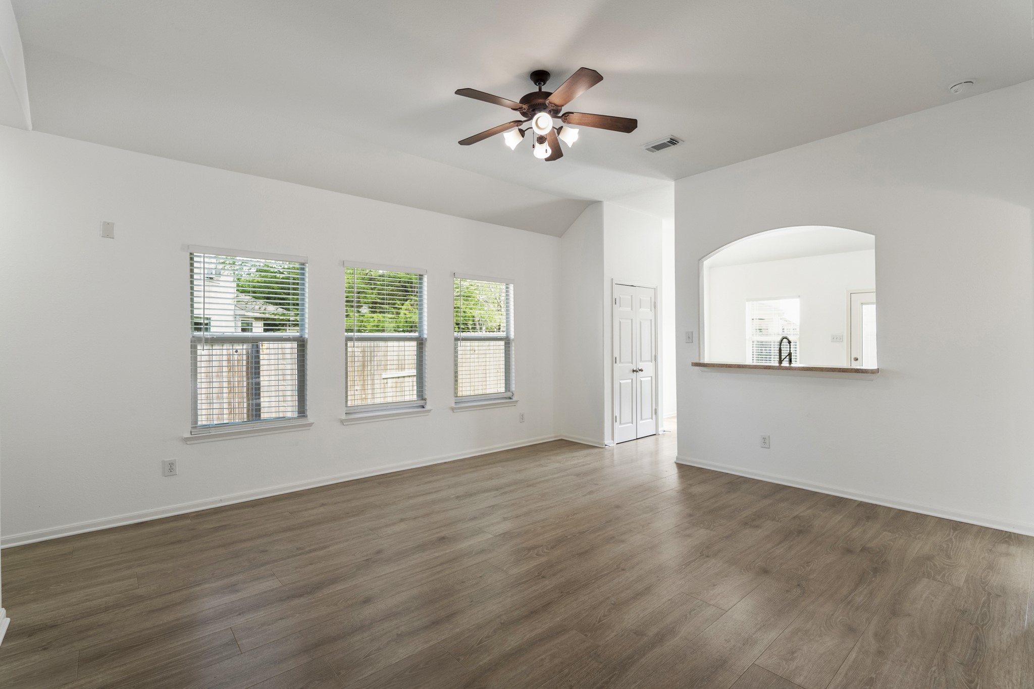 21810 Mansfield Bluff Lane Spring, TX 77379 - Photo 6 of 34 From the hallway leading to the secondary bedrooms, this view back into the living area highlights the natural light coming through a row of windows, brightening the space throughout the day. Vaulted ceilings and the open connection to the kitchen and breakfast area keep the room feeling airy and connected.
