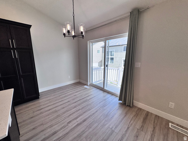 12339 Remy Road, Unit 422 Herriman, UT 84096 - Photo 20 of 36 Unfurnished dining area featuring hanging lights, lofted ceiling, and light wood-type flooring