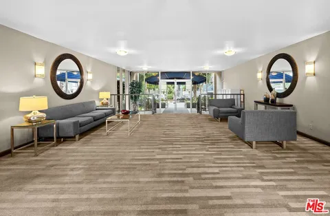 a living room with furniture a large window and a fireplace