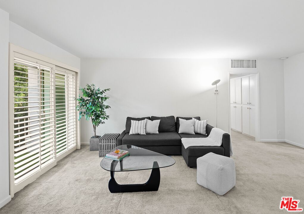 927 North Kings Road, Unit 212 West Hollywood, CA 90069 - Photo 4 of 14 a living room with furniture and flowers