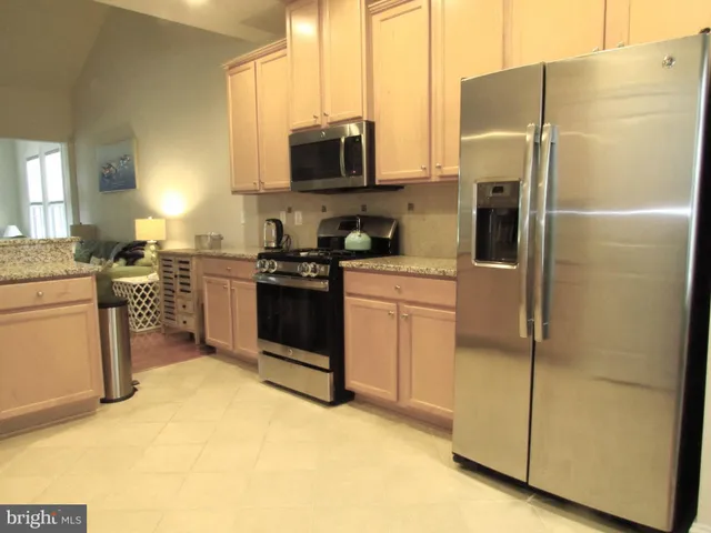 a kitchen with stainless steel appliances granite countertop a refrigerator stove and sink