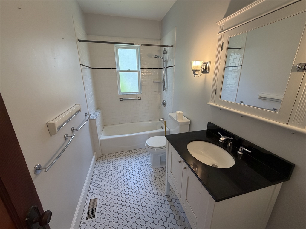 12-14 Warwick Road, Unit 12 Belmont, MA 02478 - Photo 13 of 15 a bathroom with a sink a toilet a mirror and shower