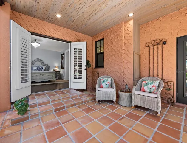 a living room with patio furniture and a rug