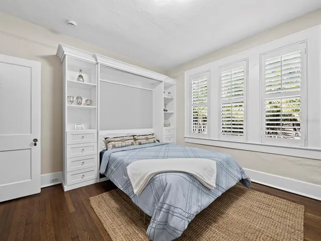 a bedroom with a bed and a large window