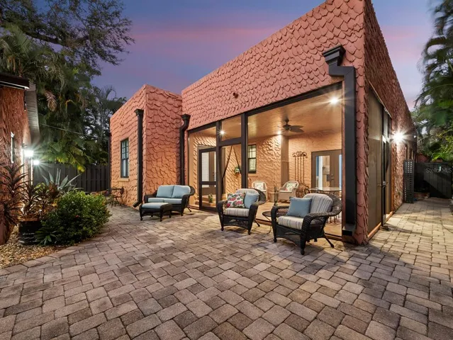 a backyard of a house with barbeque oven table and chairs