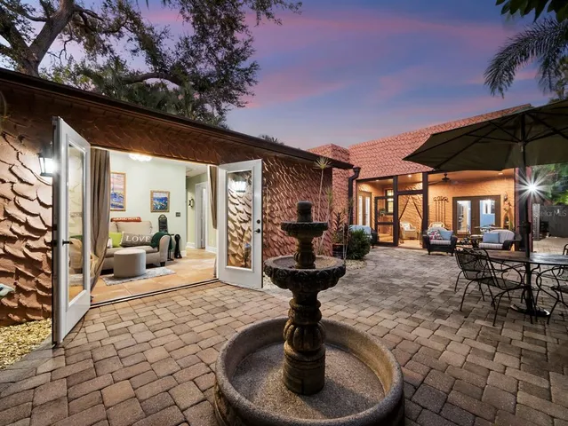 a view of a patio with table and chairs potted plants