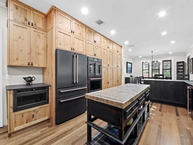 a kitchen with stainless steel appliances kitchen island granite countertop a refrigerator and a stove top oven