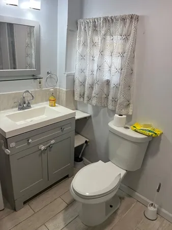 a bathroom with a sink a toilet and a mirror