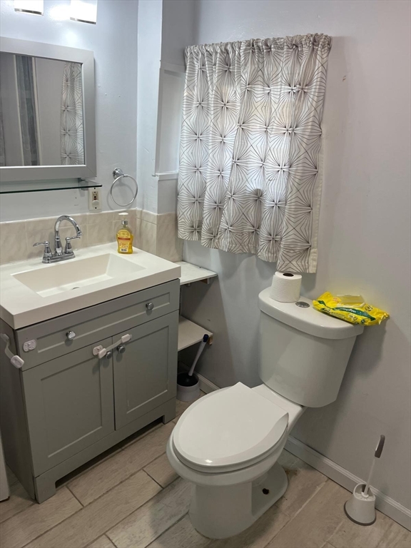 8-10 Cady Street Lowell, MA 01852 - Photo 10 of 11 a bathroom with a sink a toilet and a mirror