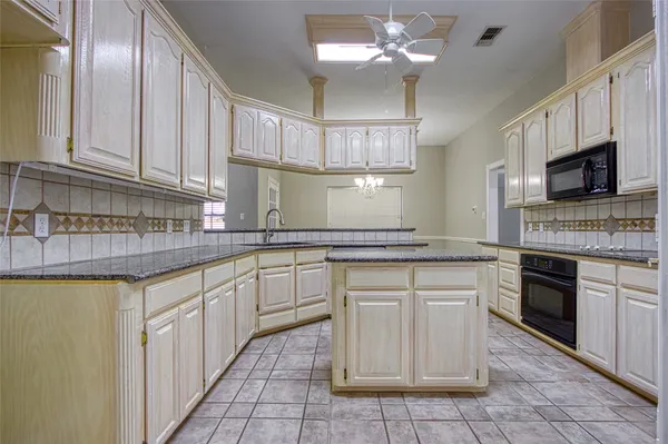 a kitchen with a stove cabinets and a microwave