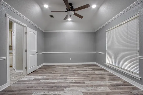 an empty room with windows and fan