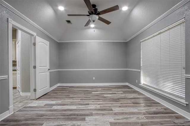 an empty room with windows and fan