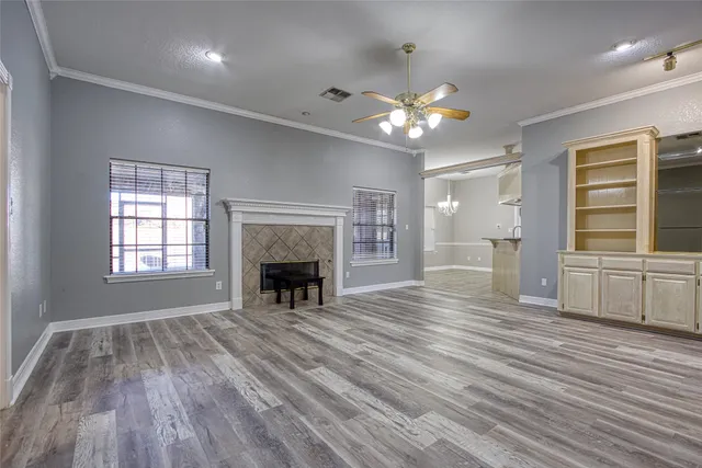 a view of an empty room with a window and fireplace