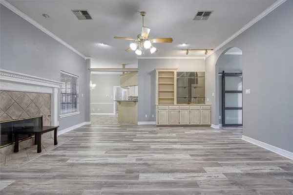a view of an empty room with window and wooden floor