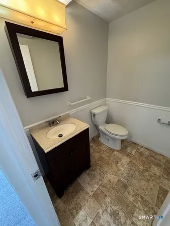 a bathroom with a toilet sink and mirror
