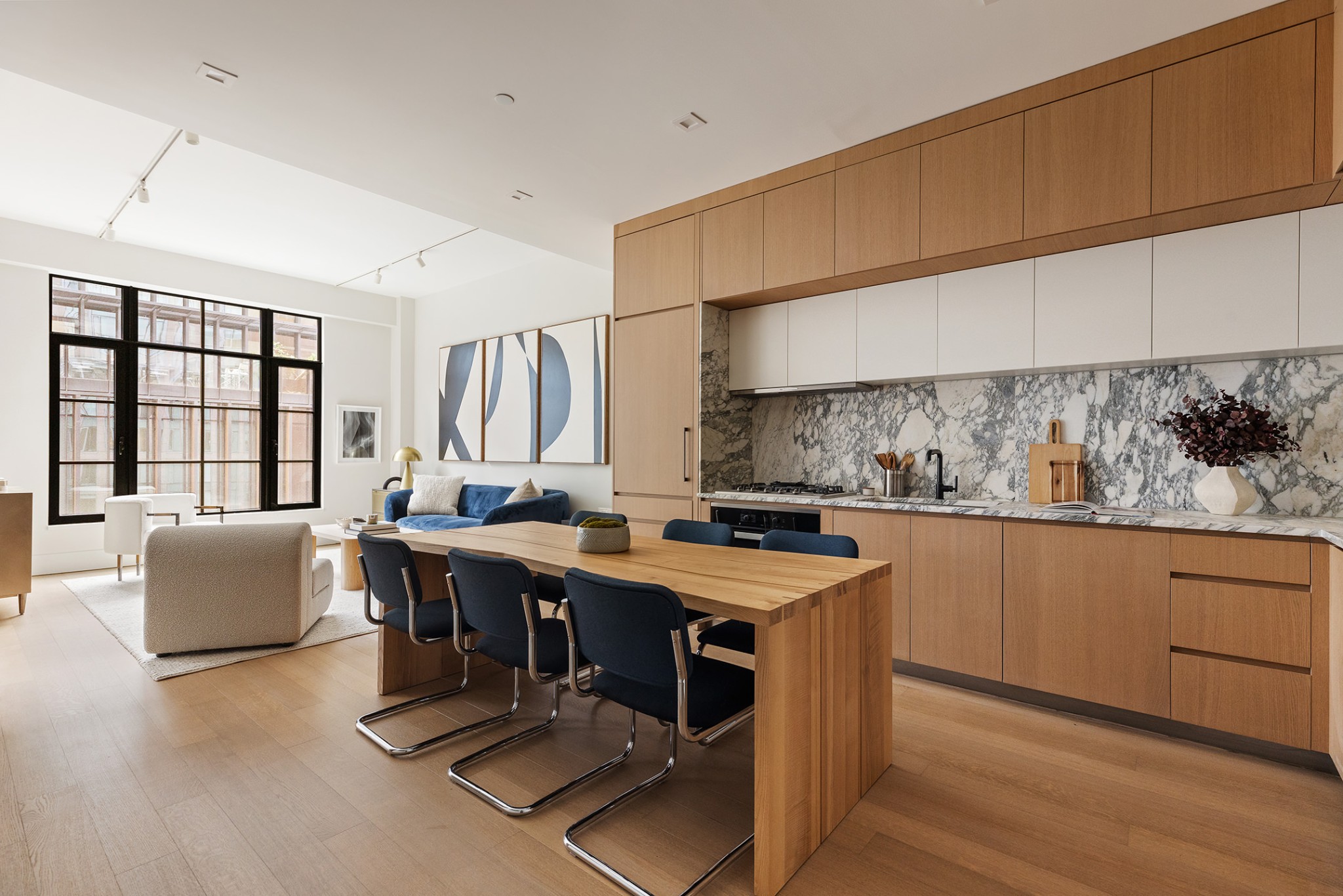517 West 29th Street, Unit 6A Manhattan, NY 10001 - Photo 3 of 15 a room with stainless steel appliances kitchen island granite countertop a table chairs sink and cabinets