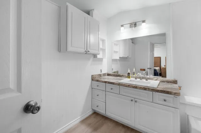 a bathroom with a granite countertop sink and mirror