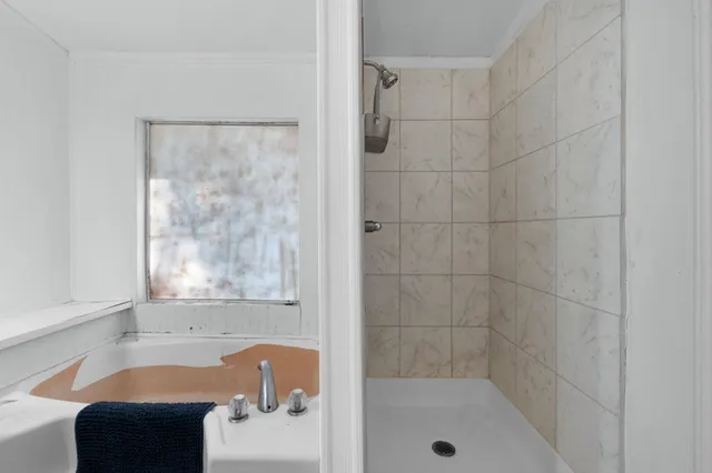 a bathroom with a tub shower and a sink