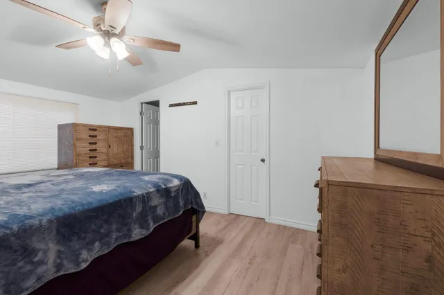 a bedroom with a bed and a ceiling fan