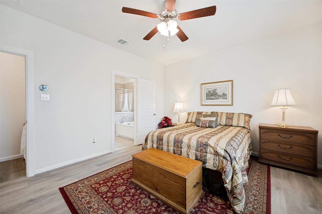 413 Wiggins Way Van Alstyne, TX 75495 - Photo 15 of 25 Bedroom featuring light wood-finish flooring, a ceiling fan with integrated lighting, and white walls