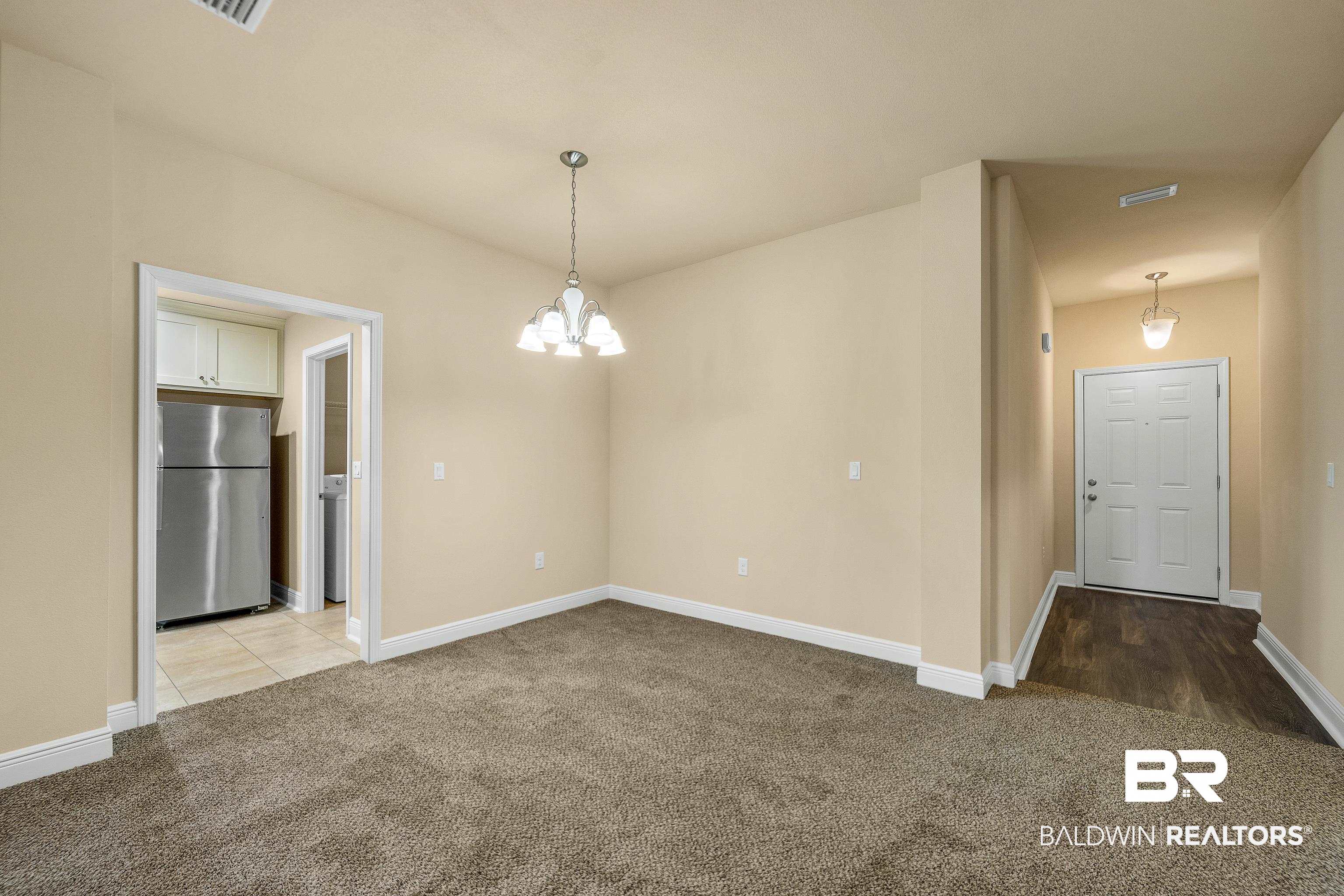 22631 Lake South Drive Foley, AL 36535 - Photo 3 of 25 Carpeted spare room with an inviting chandelier