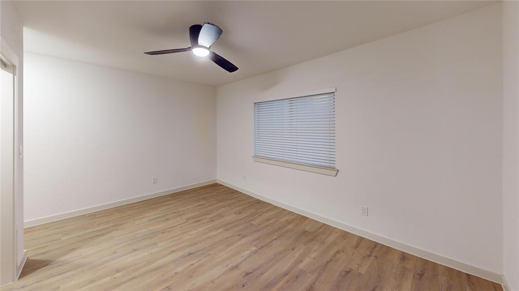 715 North Lancaster Avenue, Unit 210 Dallas, TX 75203 - Photo 12 of 22 an empty room with wooden floor chandelier fan and windows