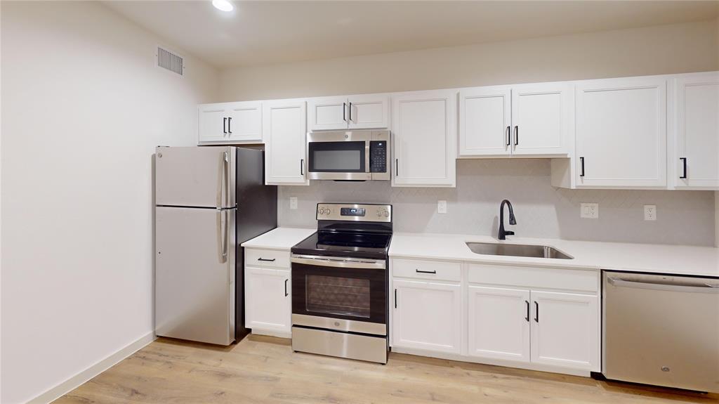 715 North Lancaster Avenue, Unit 210 Dallas, TX 75203 - Photo 15 of 22 a kitchen with white cabinets and stainless steel appliances