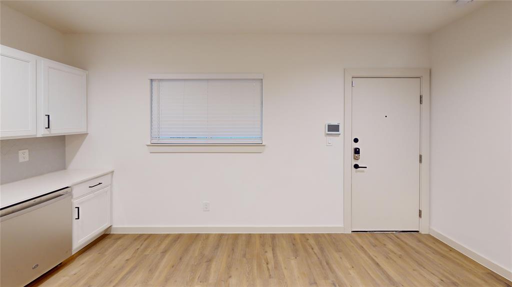 715 North Lancaster Avenue, Unit 210 Dallas, TX 75203 - Photo 17 of 22 a view of a room with wooden floor and white walls