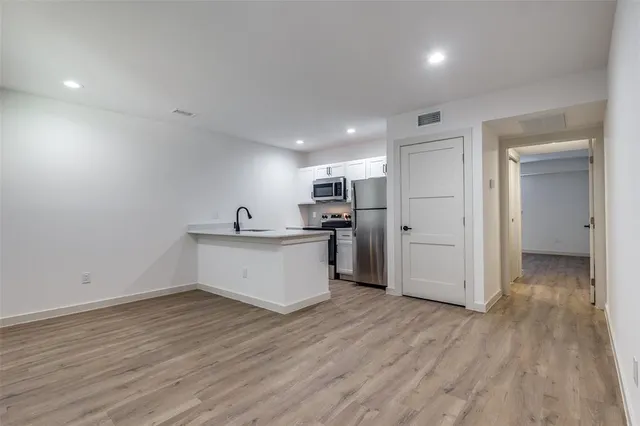 a view of open kitchen with wooden floor and electronic appliances