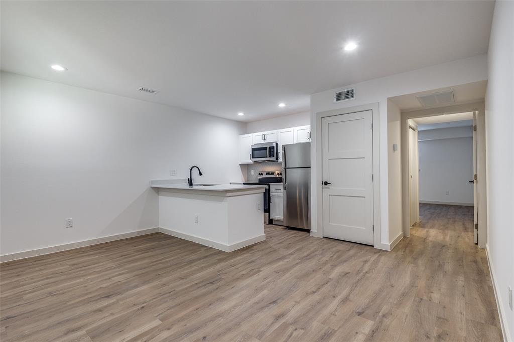 715 North Lancaster Avenue, Unit 210 Dallas, TX 75203 - Photo 19 of 22 a view of open kitchen with wooden floor and electronic appliances