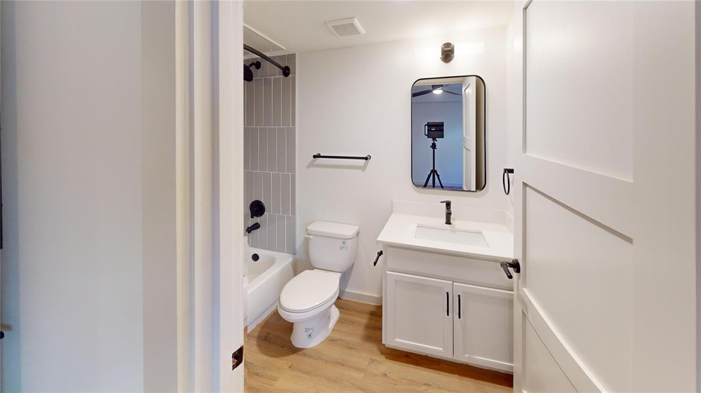 715 North Lancaster Avenue, Unit 210 Dallas, TX 75203 - Photo 2 of 22 a bathroom with a toilet sink and mirror