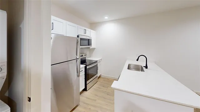 a kitchen with refrigerator a sink and cabinets