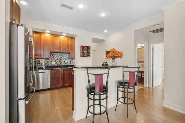 a view of a dining room kitchen with stainless steel appliances granite countertop a stove and a refrigerator