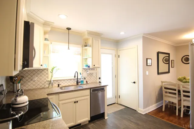 a large kitchen with a stove a sink dishwasher and a refrigerator with wooden floor