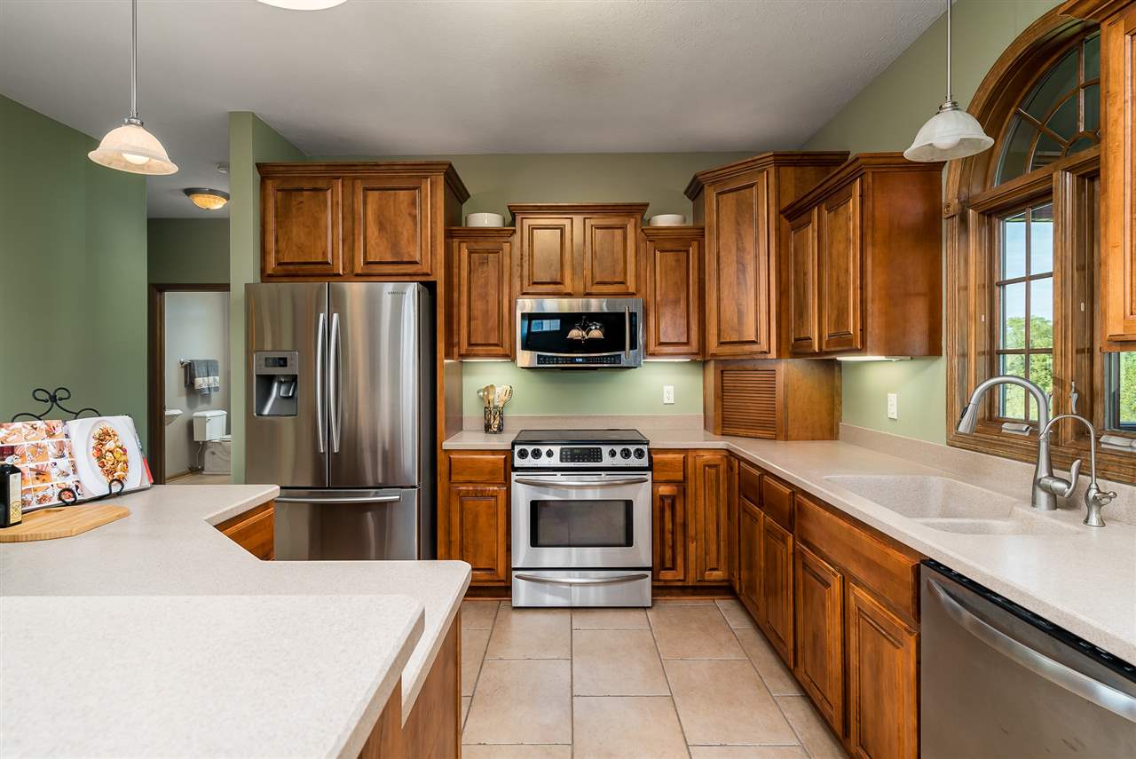 12495 Ashfield Road Caledonia, IL 61011 - Photo 8 of 25 a kitchen with stainless steel appliances granite countertop a sink stove and refrigerator