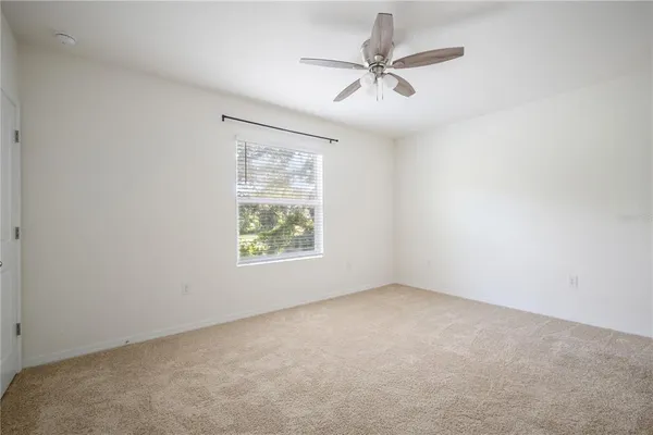 an empty room with a window and a fan