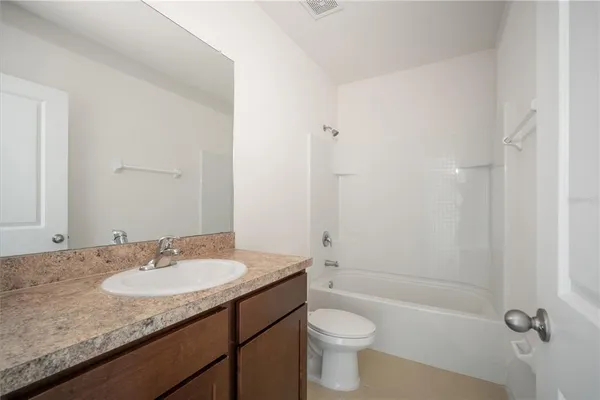 a bathroom with a granite countertop sink toilet a mirror and shower