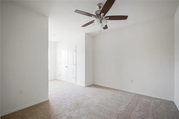 an empty room with a ceiling fan and a window