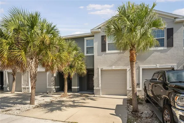 a front view of a house with a tree