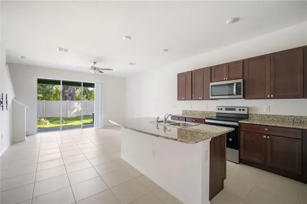 a kitchen with stainless steel appliances granite countertop a sink stove and microwave