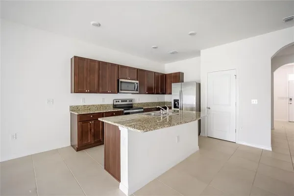 a kitchen with stainless steel appliances granite countertop a stove refrigerator sink and microwave